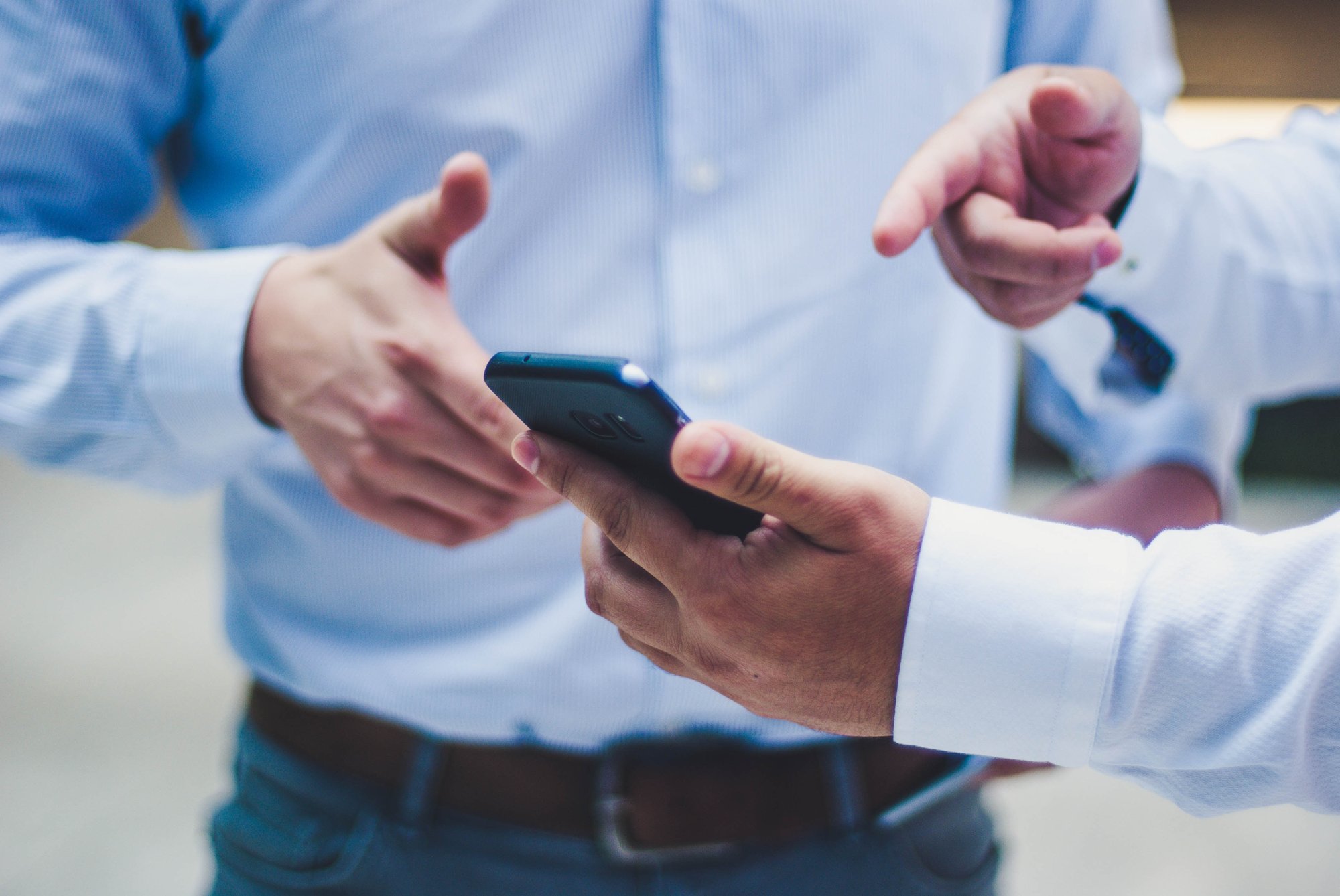 Two professionals reviewing content on a mobile phone